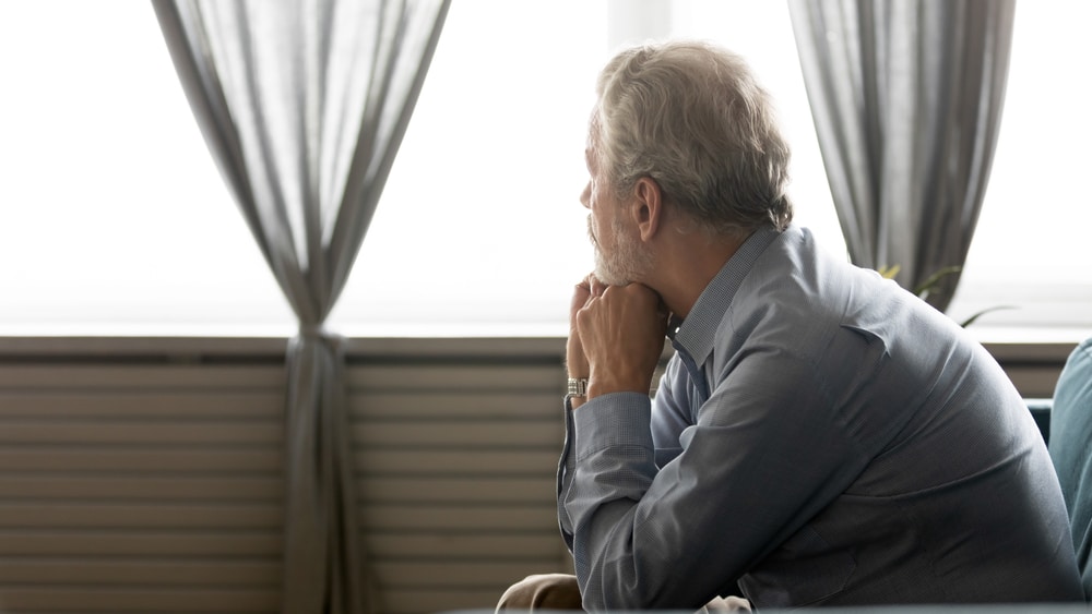 Man with rectus diastasis gazes outside his window in Chicago